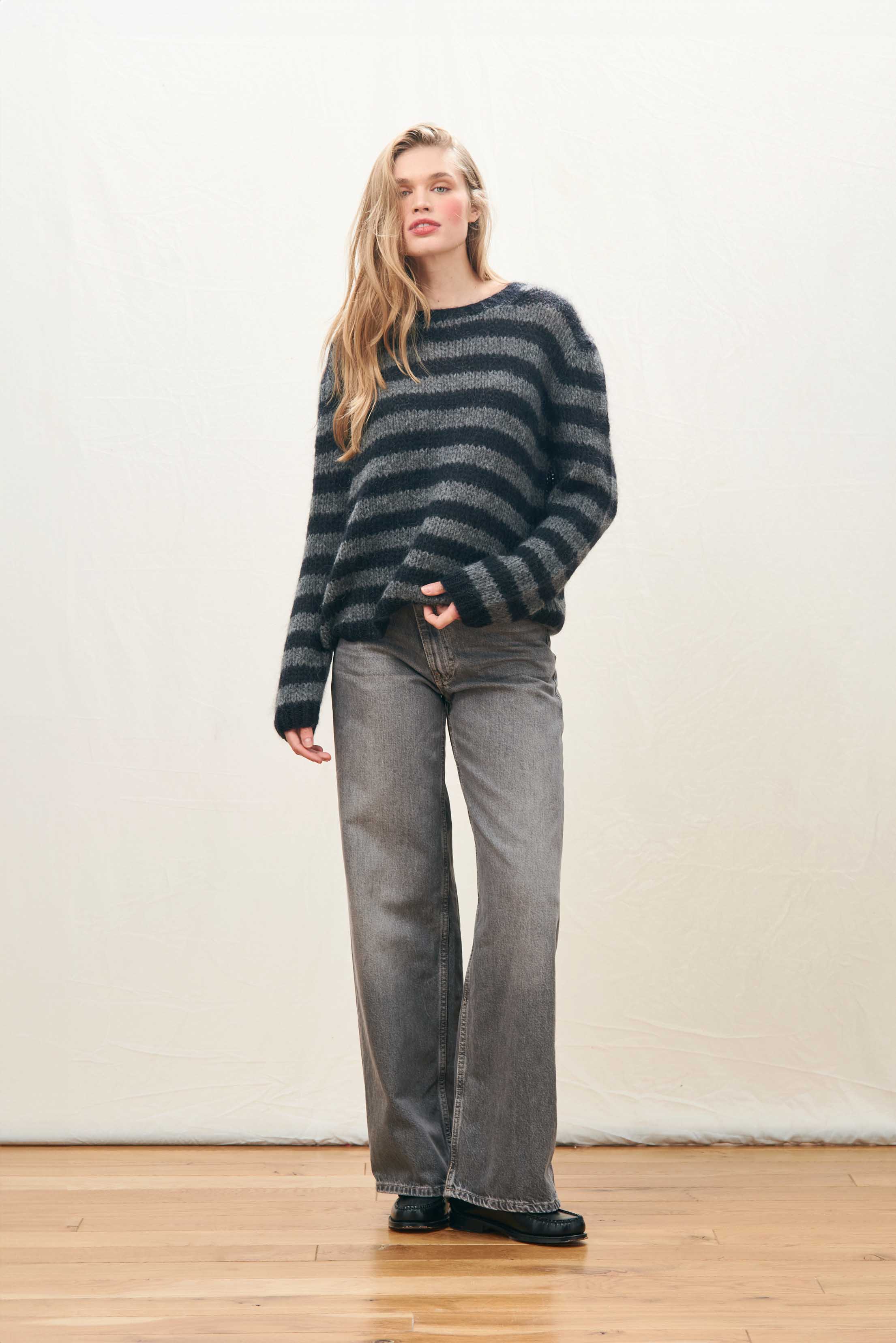 Female model wearing Jumper 1234 hand knitted mohair and wool blend hand knitted crew neck jumper in black and charcoal stripes.