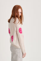 Red haired female model wearing Jumper1234 oatmeal cashmere and wool mix crew neck sweatshirt style jumper with all over pink and red love hearts intarsia back shot