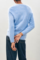 Female model wearing Jumper1234 Cashmere Brushed Crew in Blue Marl facing away from the camera