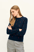 Female model wearing Jumper 1234 Cashmere navy pointelle crew neck with all over little red 3d flowers. 