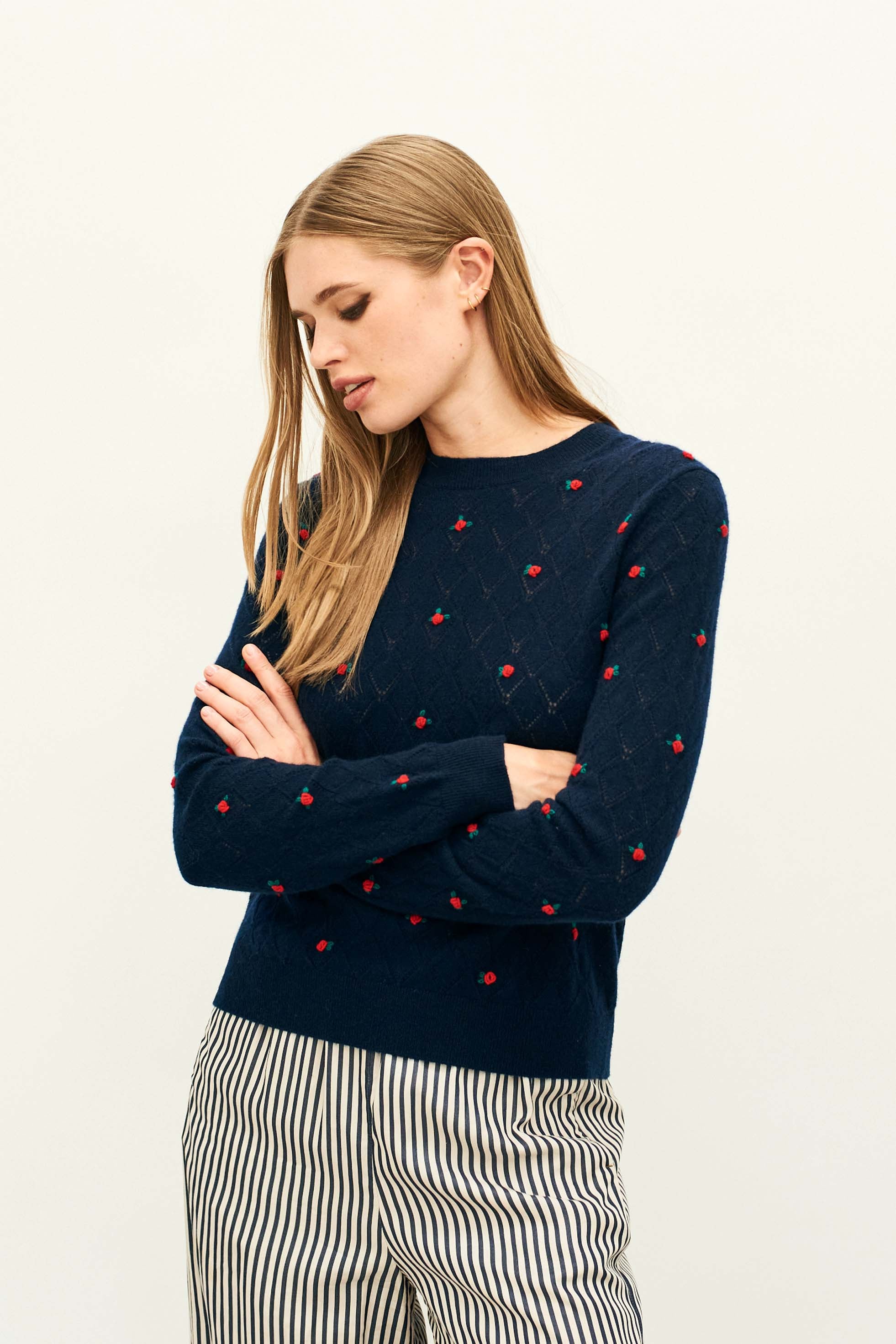 Female model wearing Jumper 1234 Cashmere navy pointelle crew neck with all over little red 3d flowers. 