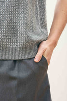 Female model wearing Jumper 1234 Oversize cashmere and wool tank in mid grey with silver lurex running through the birdseye texture. Close up.