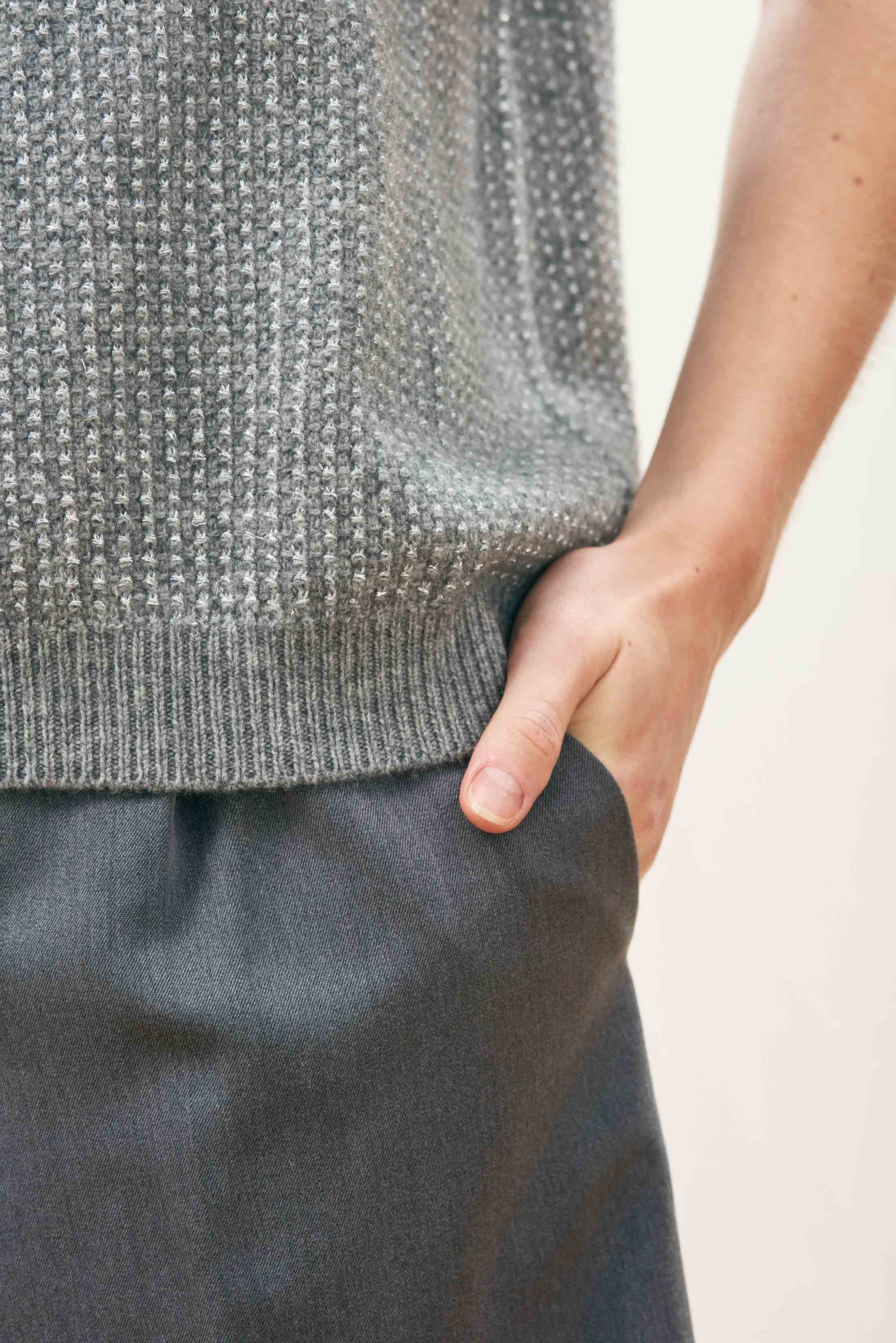Female model wearing Jumper 1234 Oversize cashmere and wool tank in mid grey with silver lurex running through the birdseye texture. Close up.