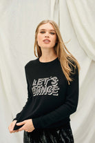 Female model wearing Jumper 1234 Black crew neck cashmere and wool jumper, with 'Let's Dance' intarsia in mid grey and silver.