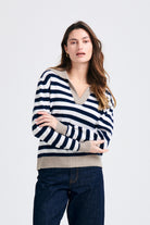Brown haired female model wearing Jumper1234 Navy and cream stripe cashmere jumper with contrast organic light brown collar and trims