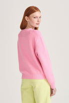 Red haired female model wearing Jumper1234 Pink cotton jumper with a collar in a fabulous all over herringbone stitch facing away from the camera