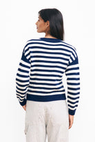 Brown haired female model wearing Jumper 1234 navy and cream stripe cashmere and wool Guernsey facing away from the camera