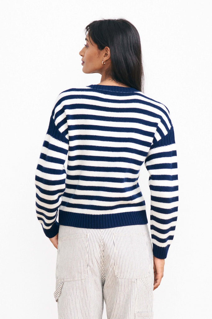 Brown haired female model wearing Jumper 1234 navy and cream stripe cashmere and wool Guernsey facing away from the camera