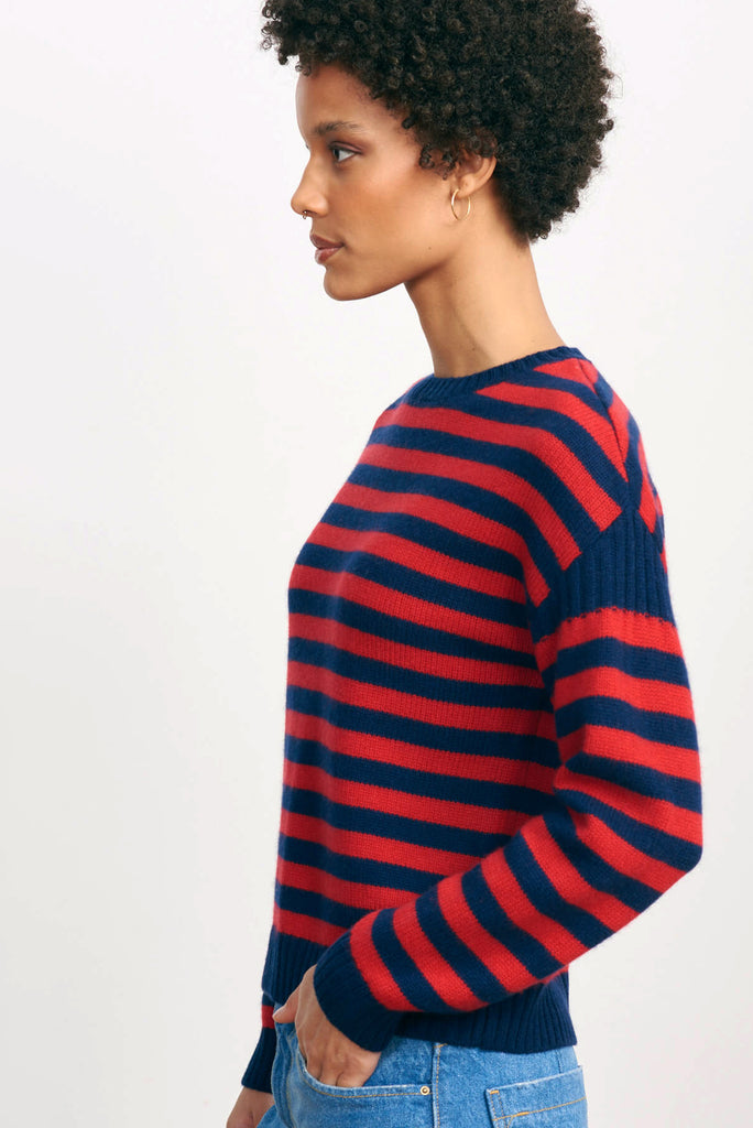 Brown haired female model wearing Jumper 1234 navy and red stripe cashmere and wool Guernsey facing away from the camera