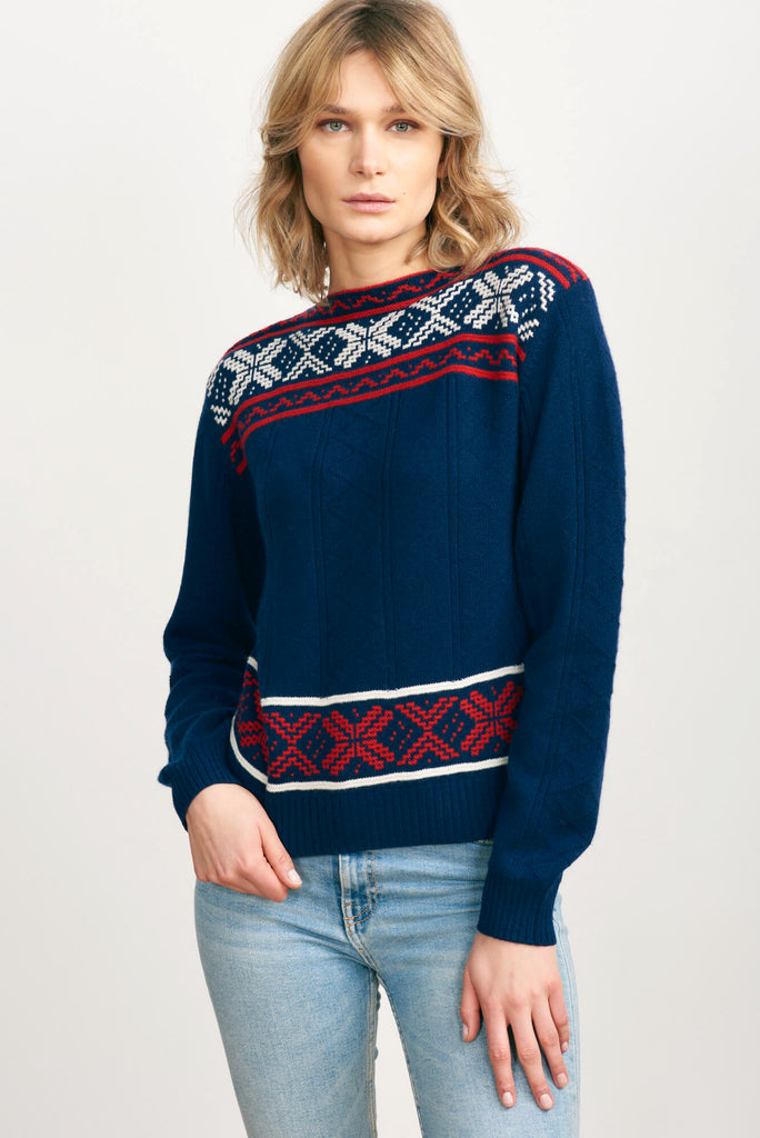 Blonde haired female model wearing Jumper1234 navy cashmere "greek guernsey" with cream and red hem and yolk detail