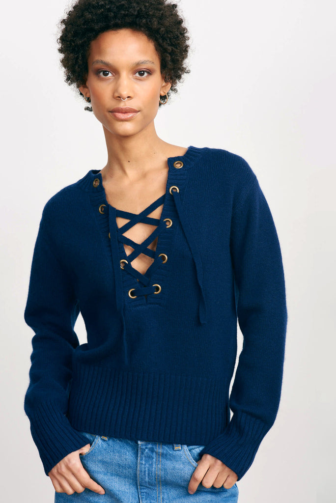 Brown haired female model wearing Jumper1234 lace up cashmere vee neck in navy