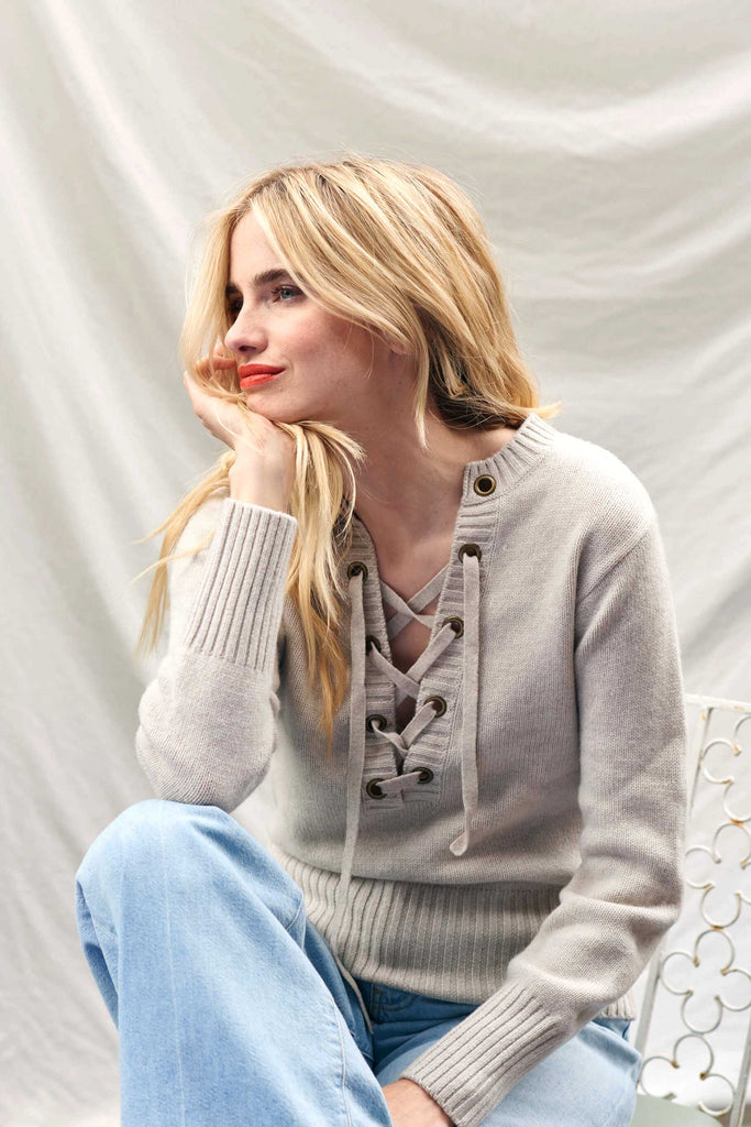 Blonde female model wearing Jumper1234 lace up cashmere vee neck in oatmeal