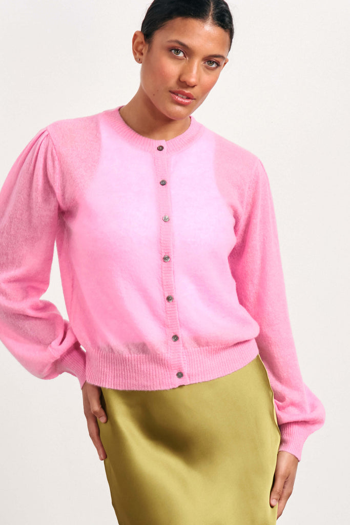 Brown haired female model wearing Jumper1234 pink lightweight merino "Puff Sleeve cardigan" 