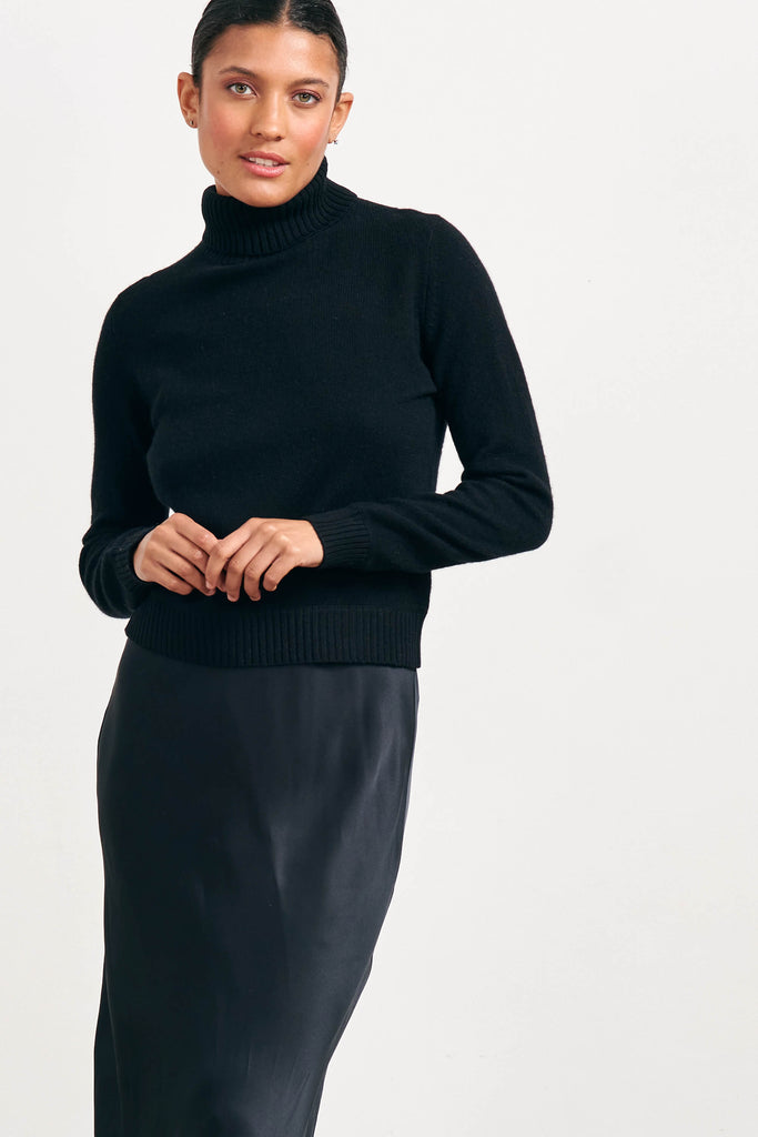 Brown haired female model wearing Jumper1234 lightweight cashmere roll neck in black 