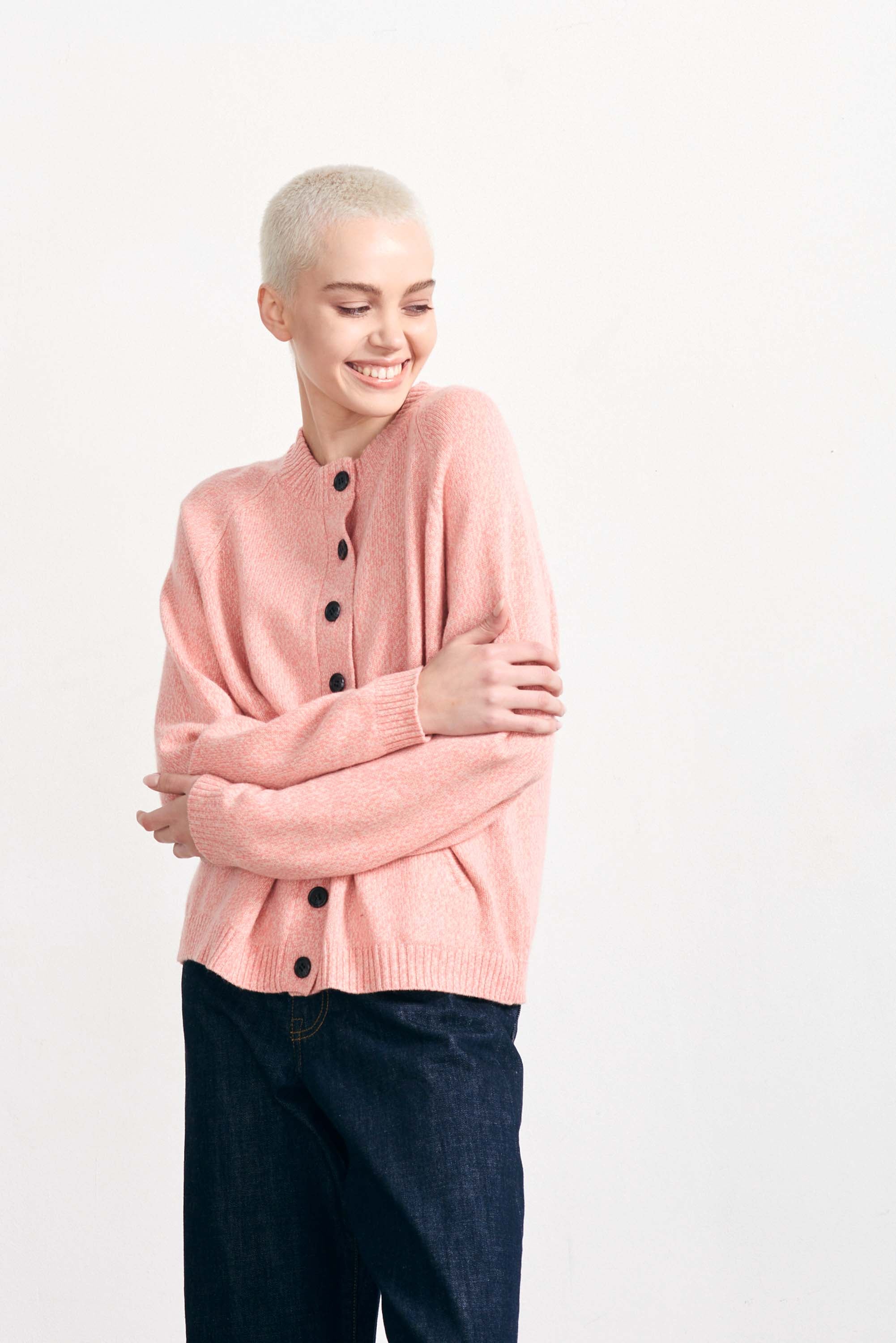 Blonde female model wearing Jumper 1234 cashmere and wool heavier weight round neck cardigan in coral marl