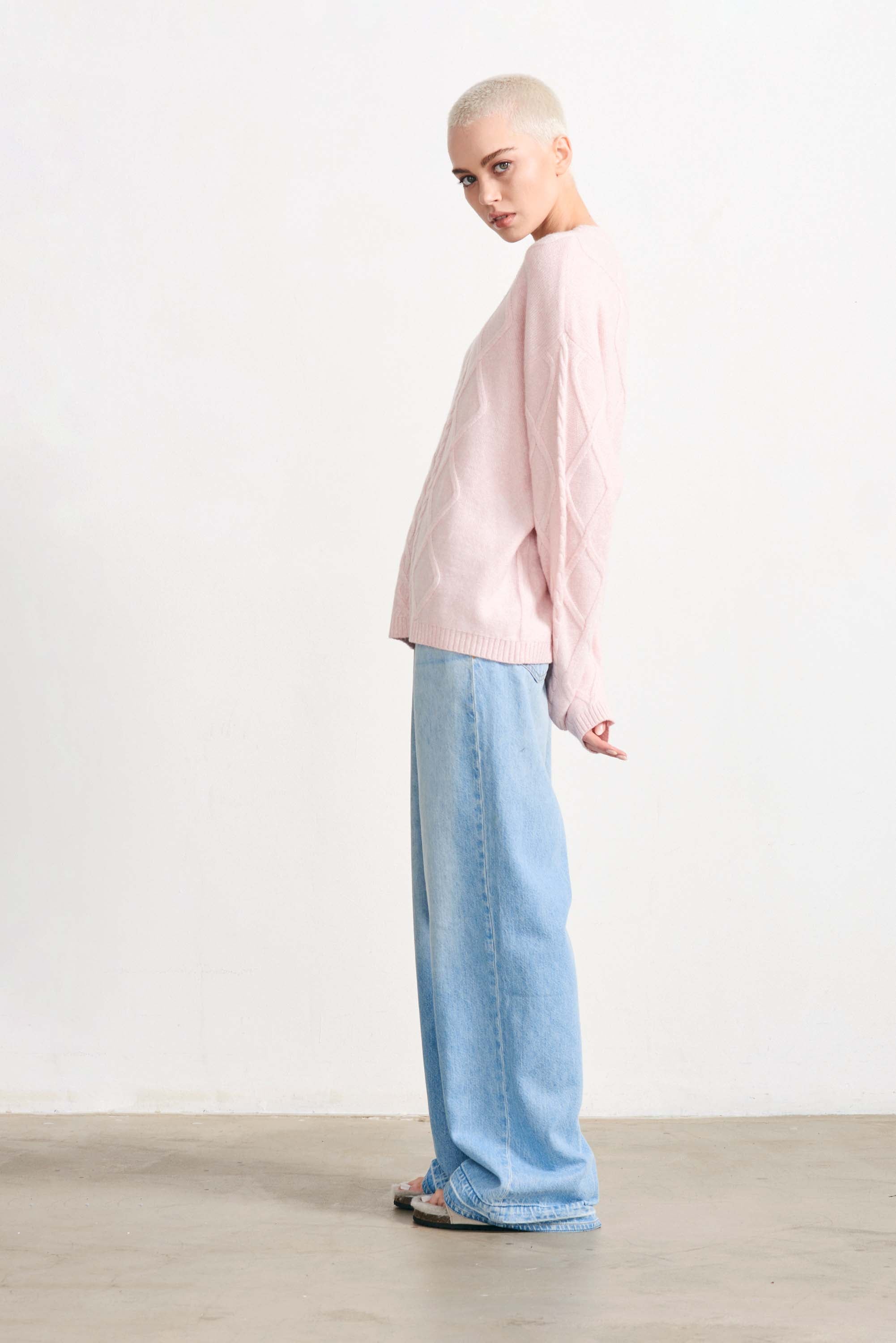 Blonde female model wearing Jumper 1234 cashmere and wool heavier weight Aran crew neck jumper in pale pink marl