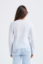 brown haired female model wearing Jumper1234 pale blue lighter weight crew neck cashmere jumper facing away from the camera