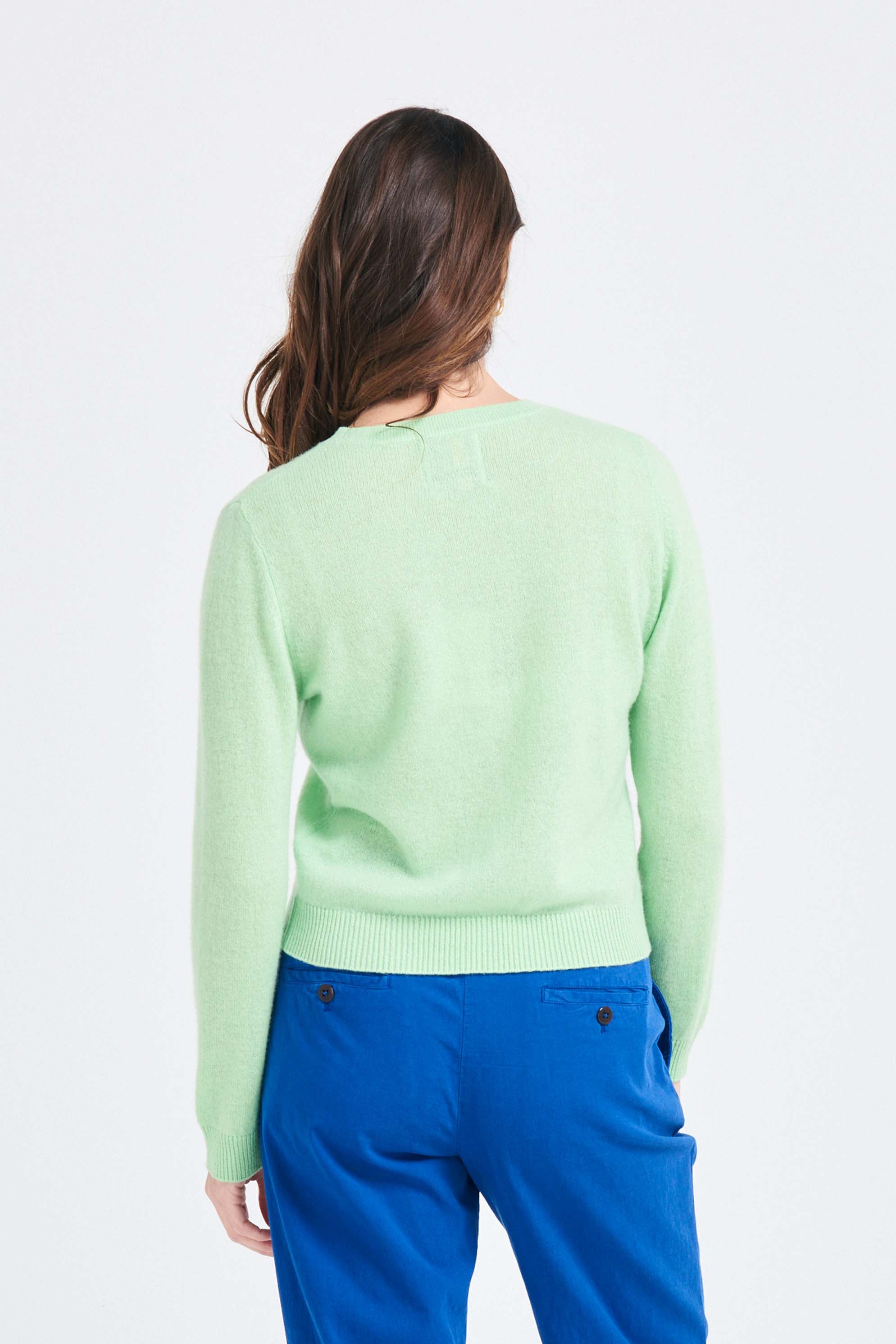 Brown haired female model wearing Jumper1234 Lime green lighter weight crew neck cashmere jumper facing away from the camera