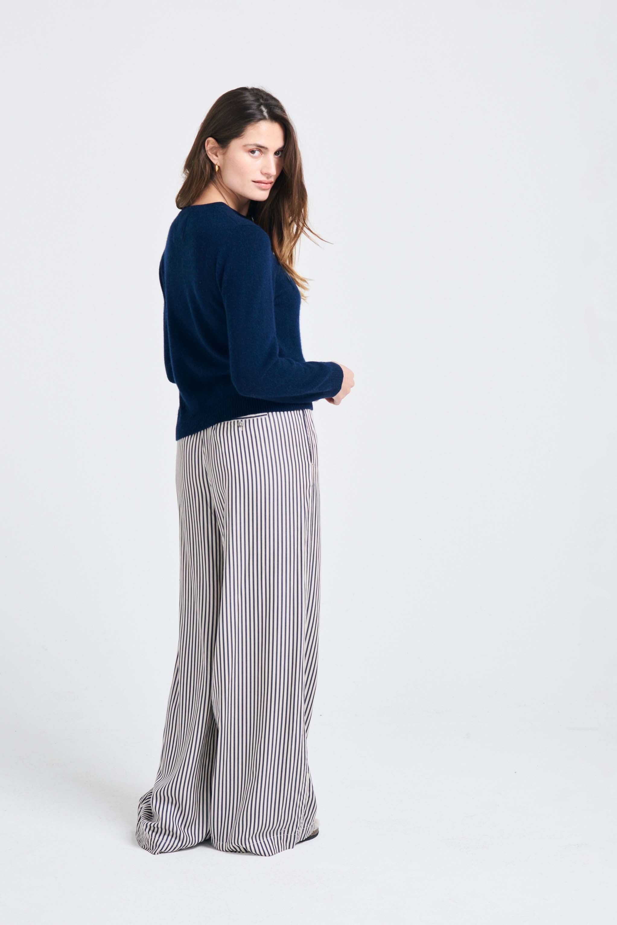 Brown haired female model wearing Jumper1234 Navy lighter weight crew neck cashmere jumper facing away from the camera