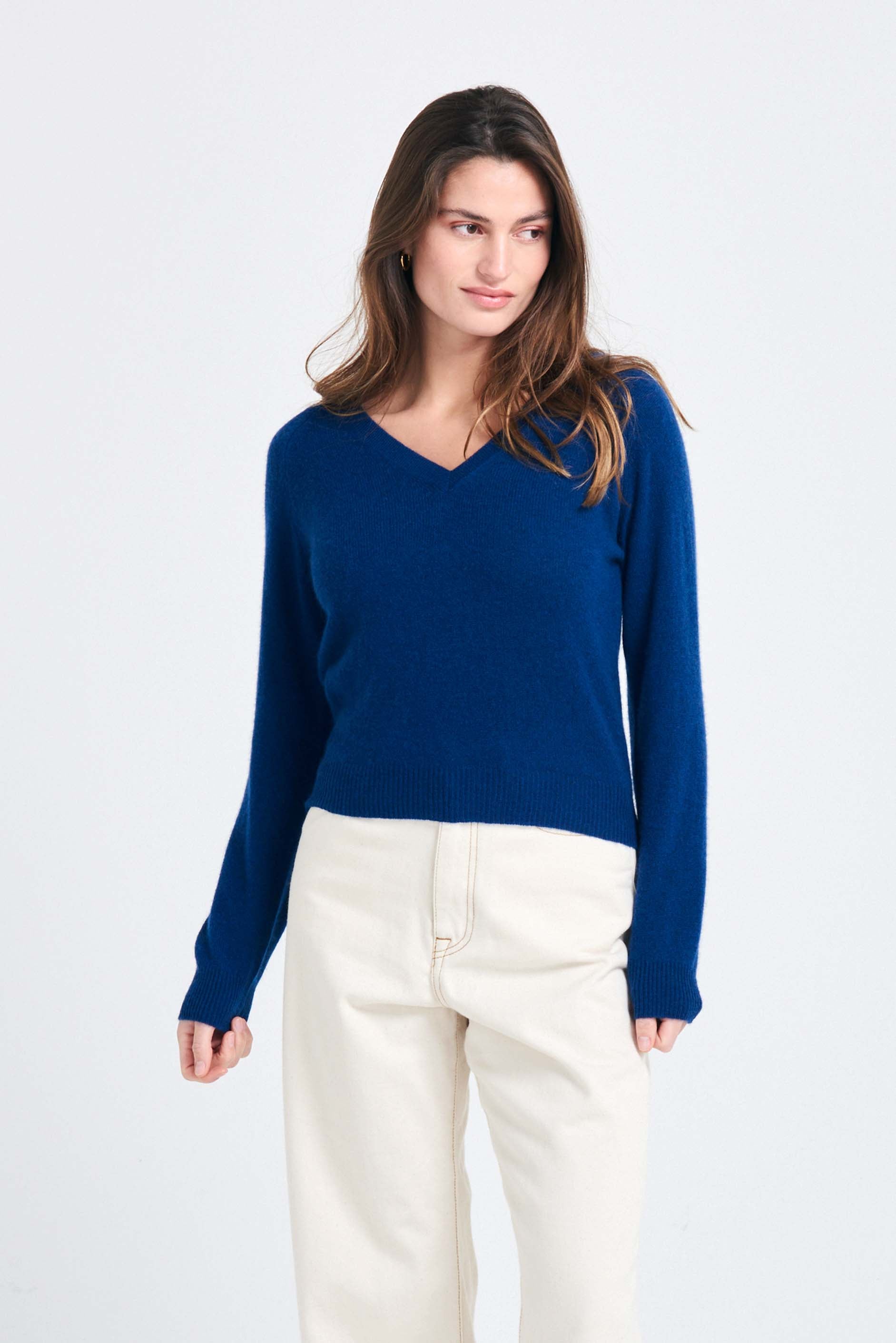 Brown haired female model wearing Jumper1234 Denim blue lighter weight vee neck cashmere jumper