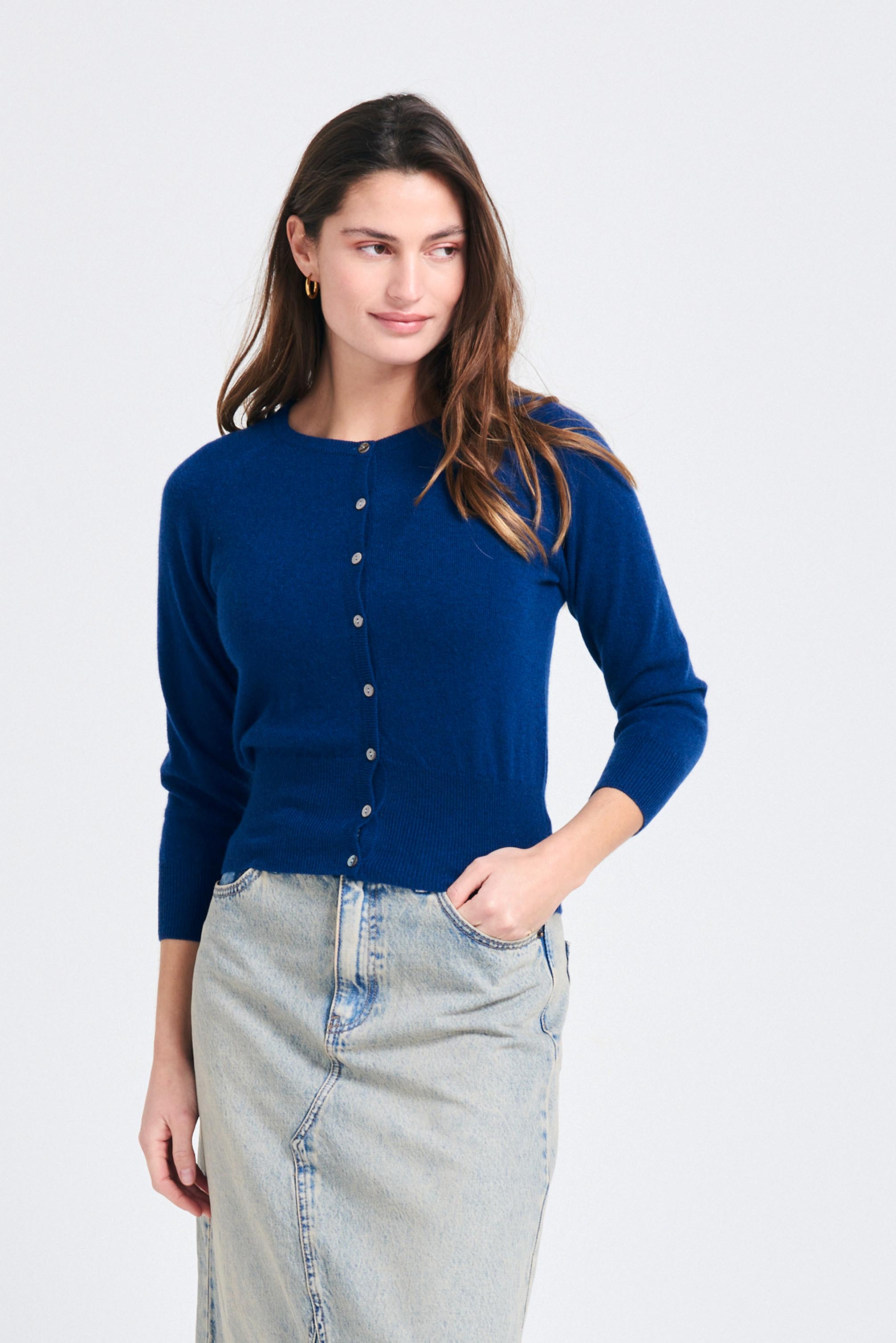 Brown haired female model wearing Jumper1234 neat fit cashmere round neck cardigan in denim blue