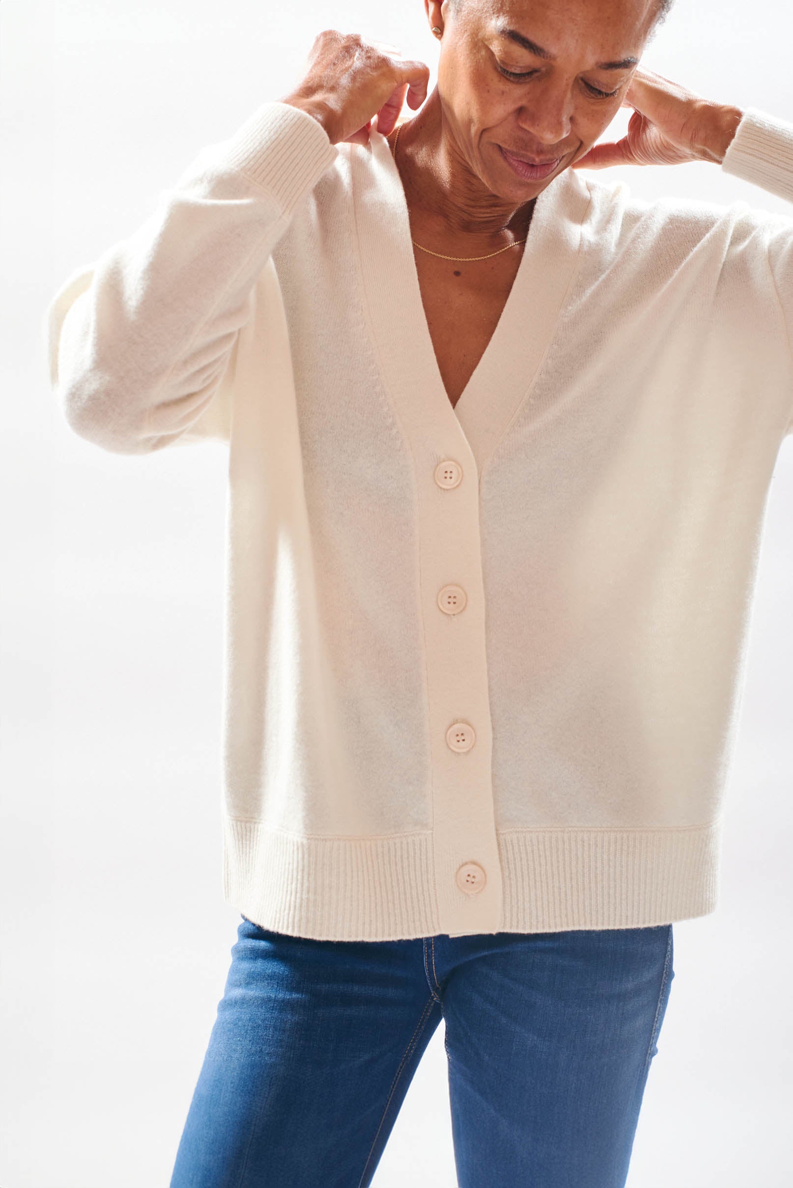 Model wearing Jumper1234 boyfriend fit cashmere vee neck cardigan in cream