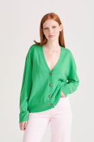Red haired female model wearing Oversize cashmere vee neck cardigan in bright green
