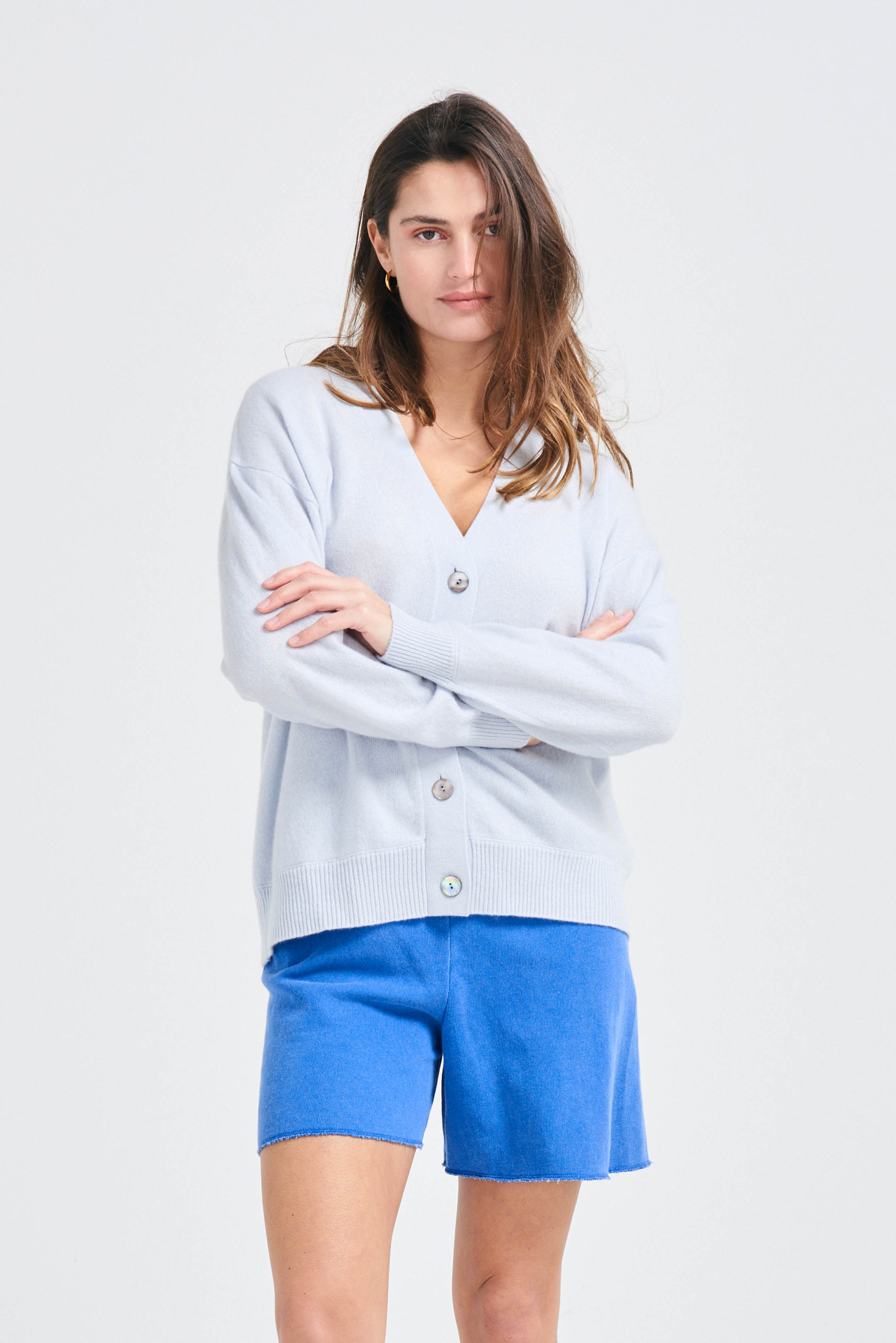 Brown haired female model wearing Jumper1234 Oversize cashmere vee neck cardigan in pale blue