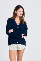 Brown haired female model wearing Jumper1234 Oversize cashmere vee neck cardigan in navy
