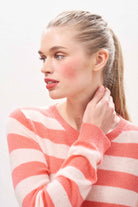 Female model wearing Jumper 1234 lightweight cashmere stripe crew neck in coral and pale pink.