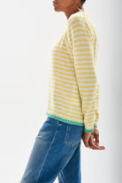 Model wearing Jumper 1234 cashmere little stripe crew with lemon and cream stripes and a contrast mint tipping stood sideways 