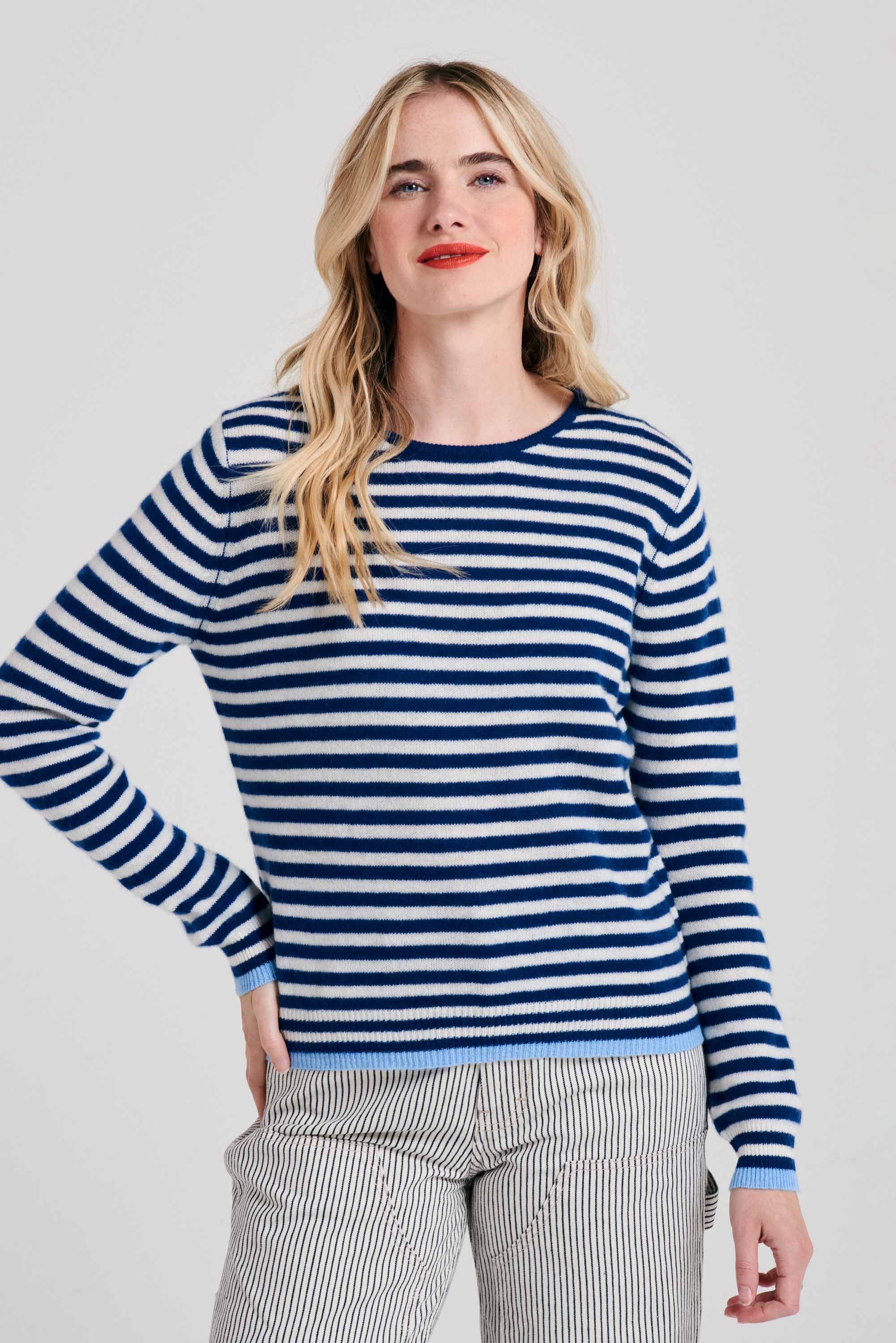Blonde female model wearing Jumper1234 Little stripe cashmere crew neck jumper in denim and cream, with wedgewood blue tipped ribs