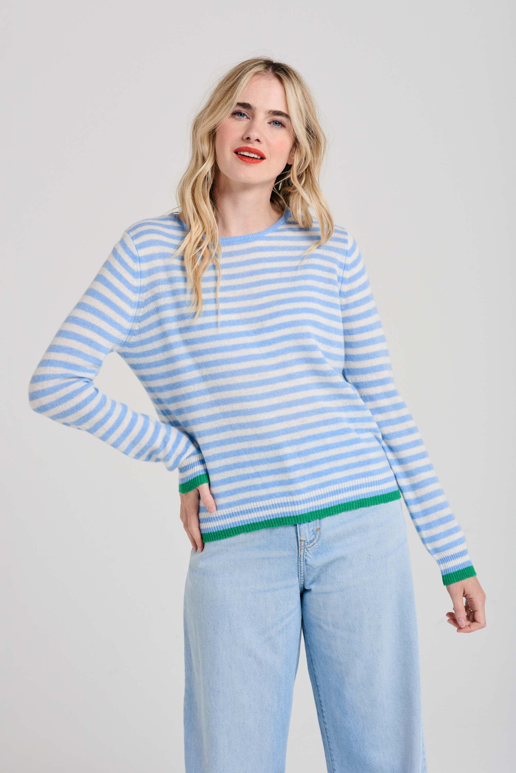 Blonde female model wearing Jumper1234 Little stripe cashmere crew neck jumper in wedgewood blue and cream, with bright green tipped ribs