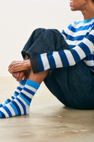 Female model wearing Jumper1234 Cashmere Gradient Stripe Socks in varied shade of blue