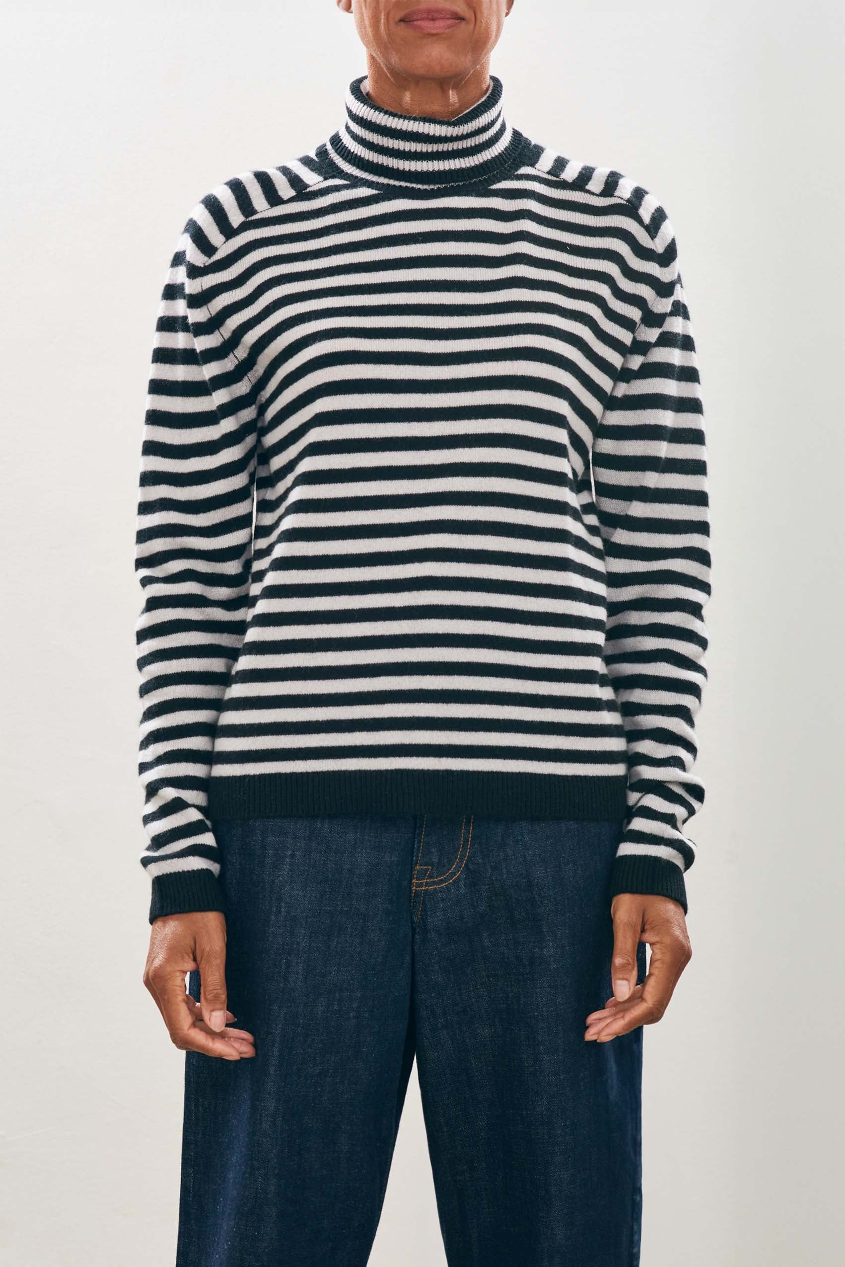 female model wearing jumper1234 Narrow Stripe Cashmere Roll Collar in Black and Fog close up