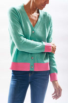 Model wearing Jumper1234 Mint green vee neck cardigan with contrast pink ribs