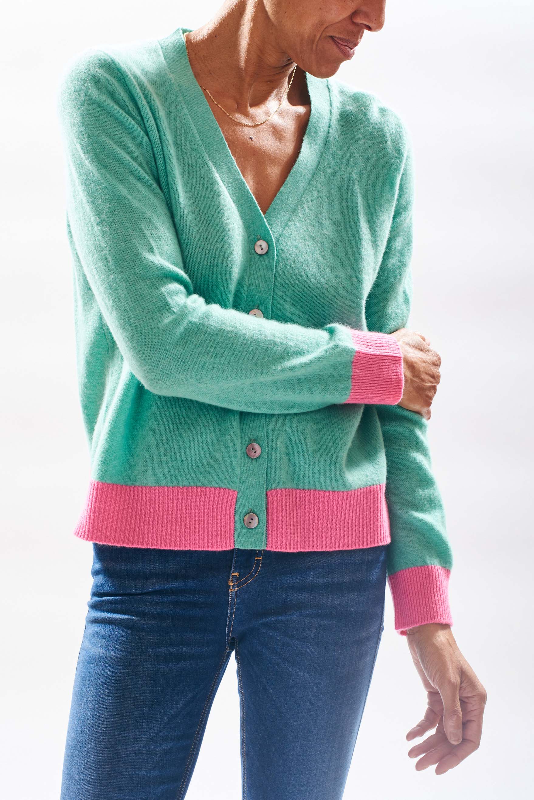 Model wearing Jumper1234 Mint green vee neck cardigan with contrast pink ribs