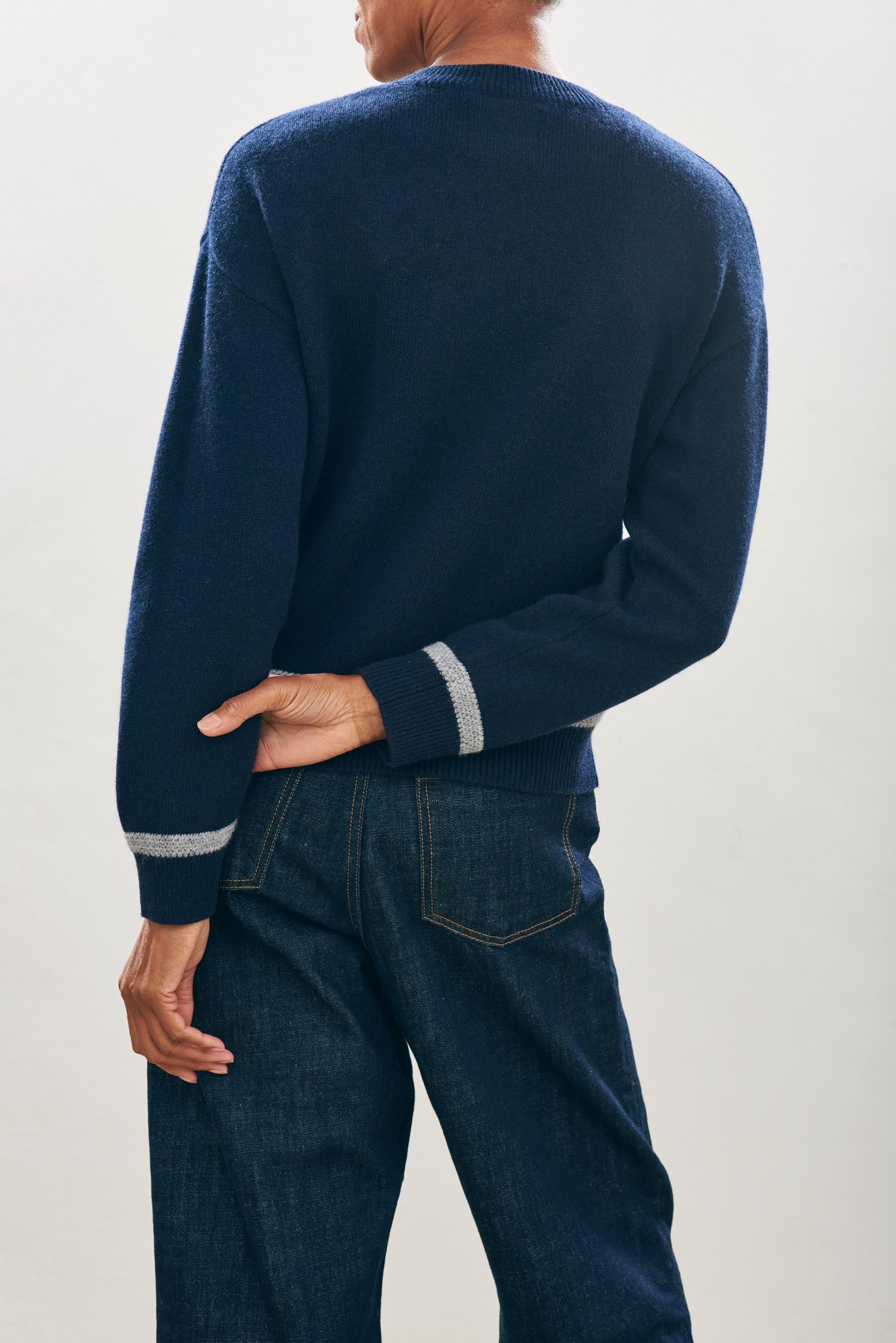 female model wearing jumper1234 Cashmere Wool Heavy Trim Crew in Navy and Grey facing away from the camera 