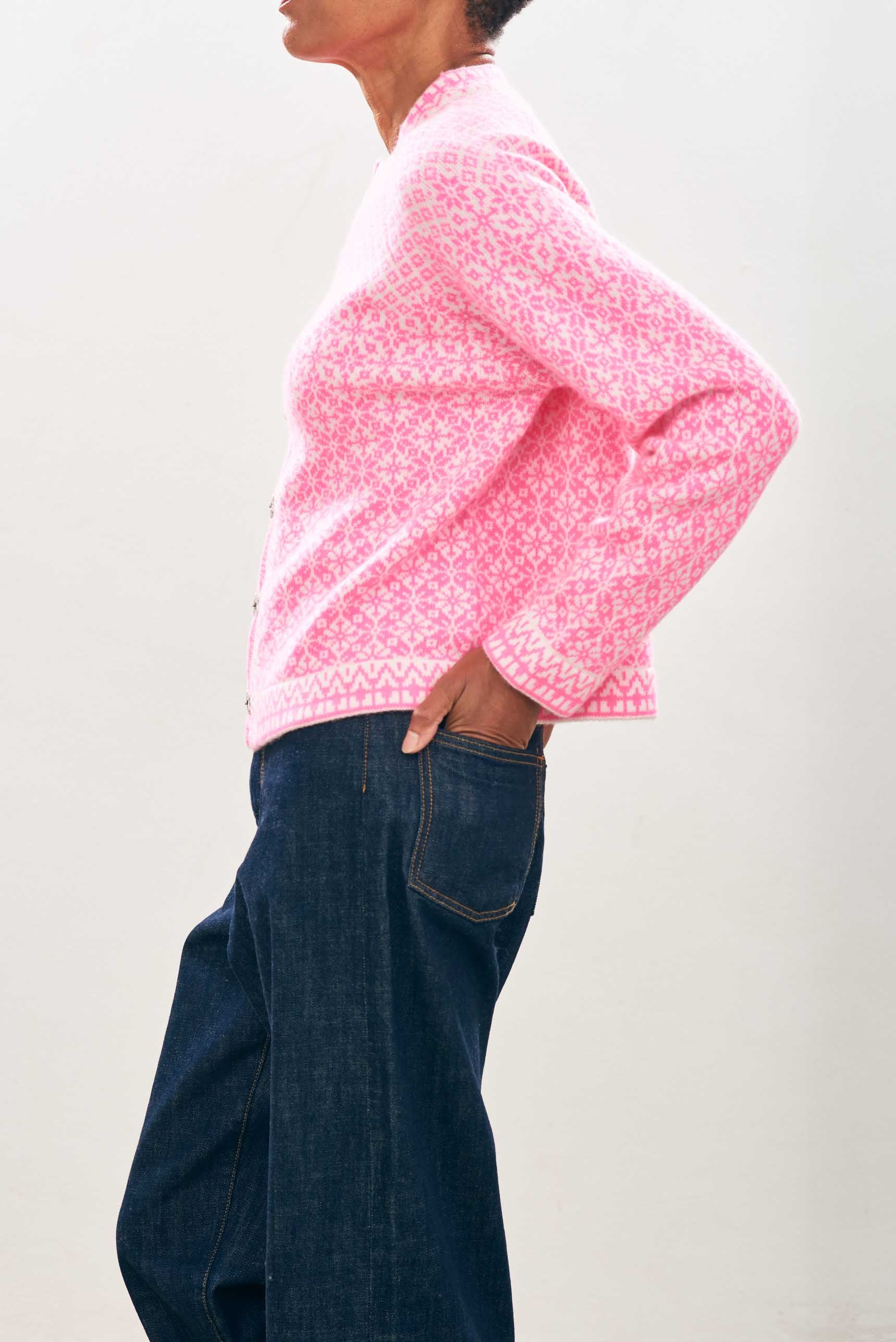 female model wearing jumper1234 Cashmere Wool Norse Cardigan in Cream and Neon Pink facing sideways to the camera