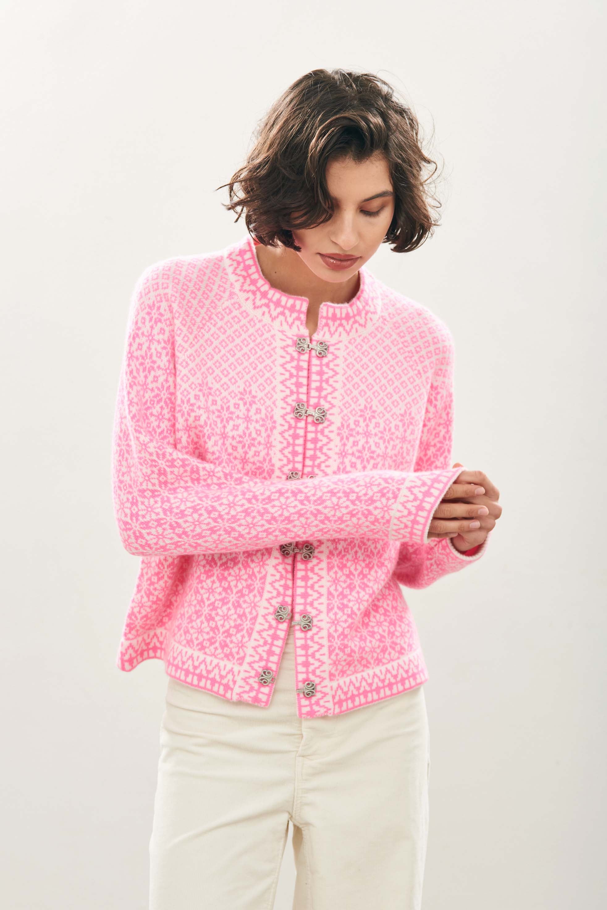 female model wearing jumper1234 Cashmere Wool Norse Cardigan in Cream and Neon Pink facing towards the camera
