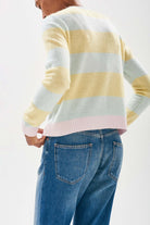 Model wearing Jumper 1234 cashmere pale green and lemon stripe cashmere crew neck with contrast pale pink ribs facing away from the camera