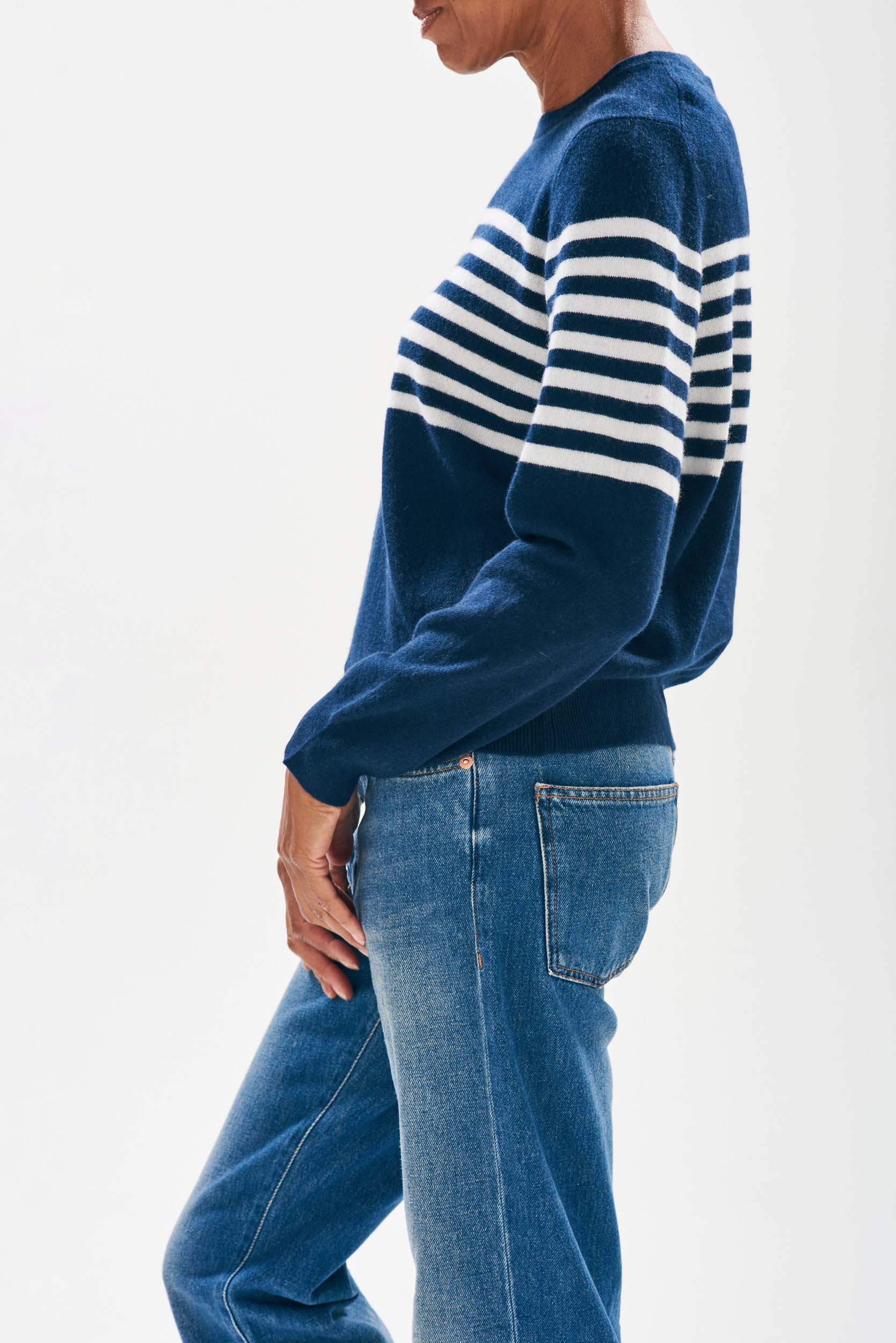 Model wearing Jumper1234 Navy cashmere crew neck jumper with cream stripe block running across the middle of the chest, with a button detail at the back neck facing sideways