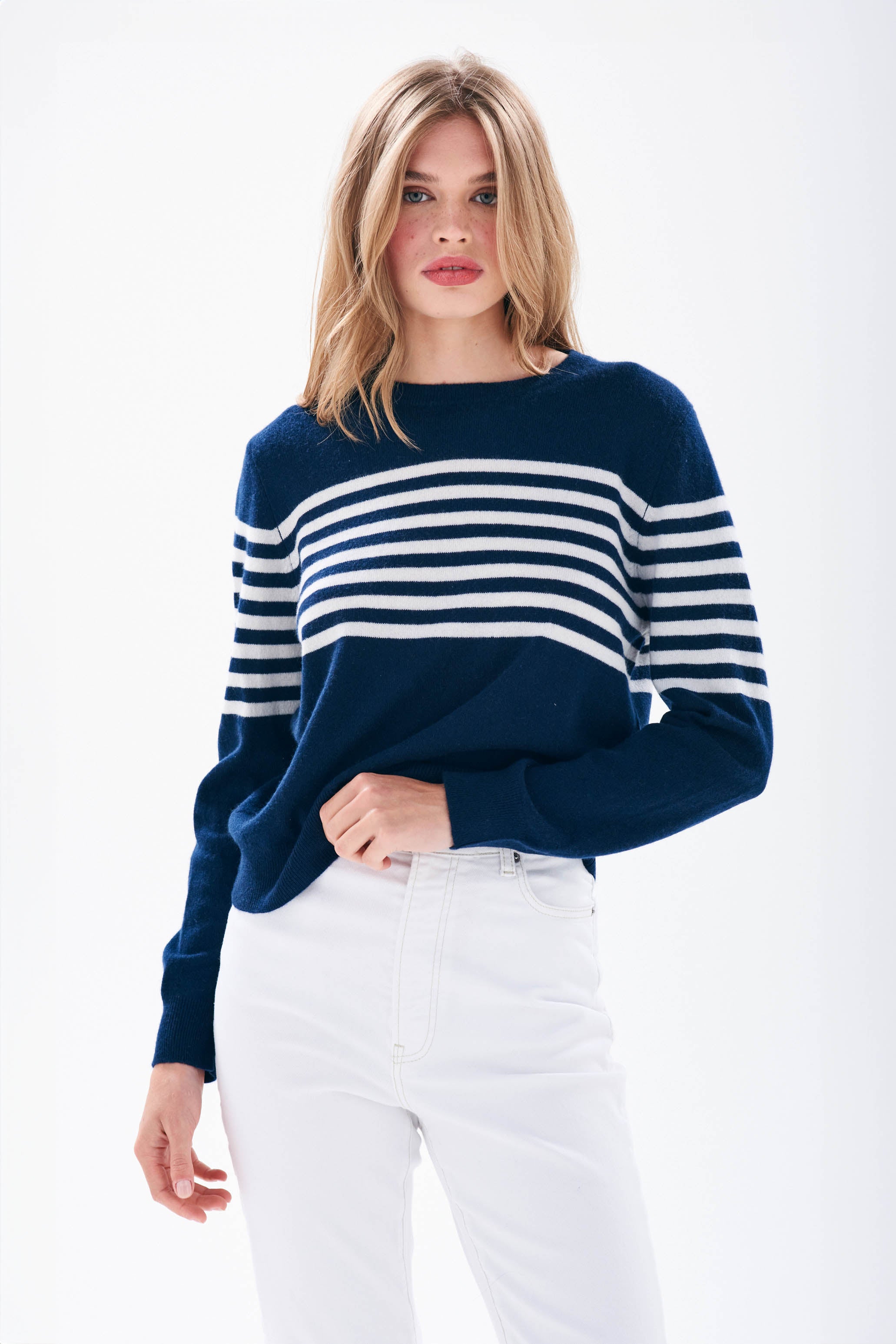 Model wearing Jumper1234 Navy cashmere crew neck jumper with cream stripe block running across the middle of the chest, with a button detail at the back neck