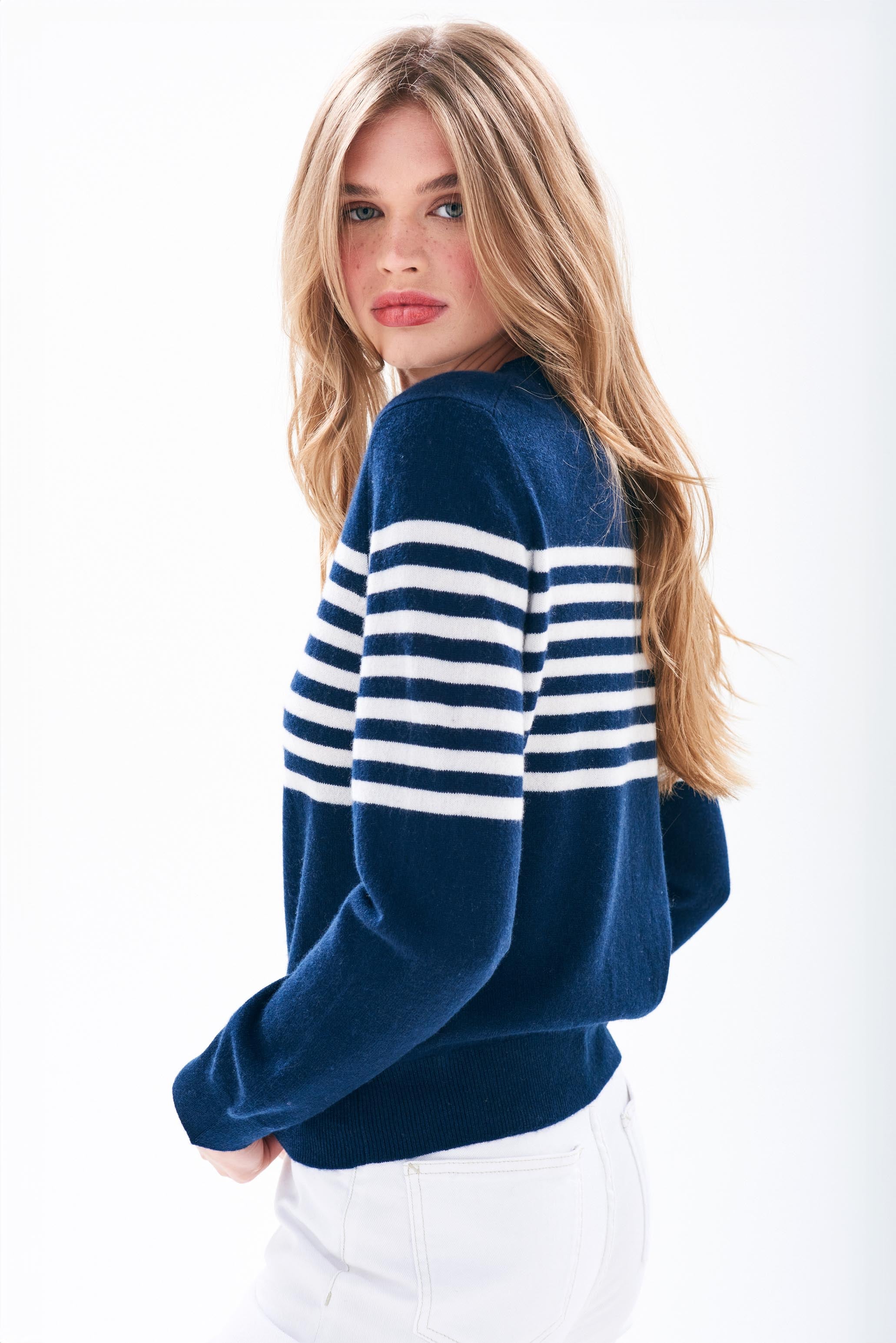 Model wearing Jumper1234 Navy cashmere crew neck jumper with cream stripe block running across the middle of the chest, with a button detail at the back neck