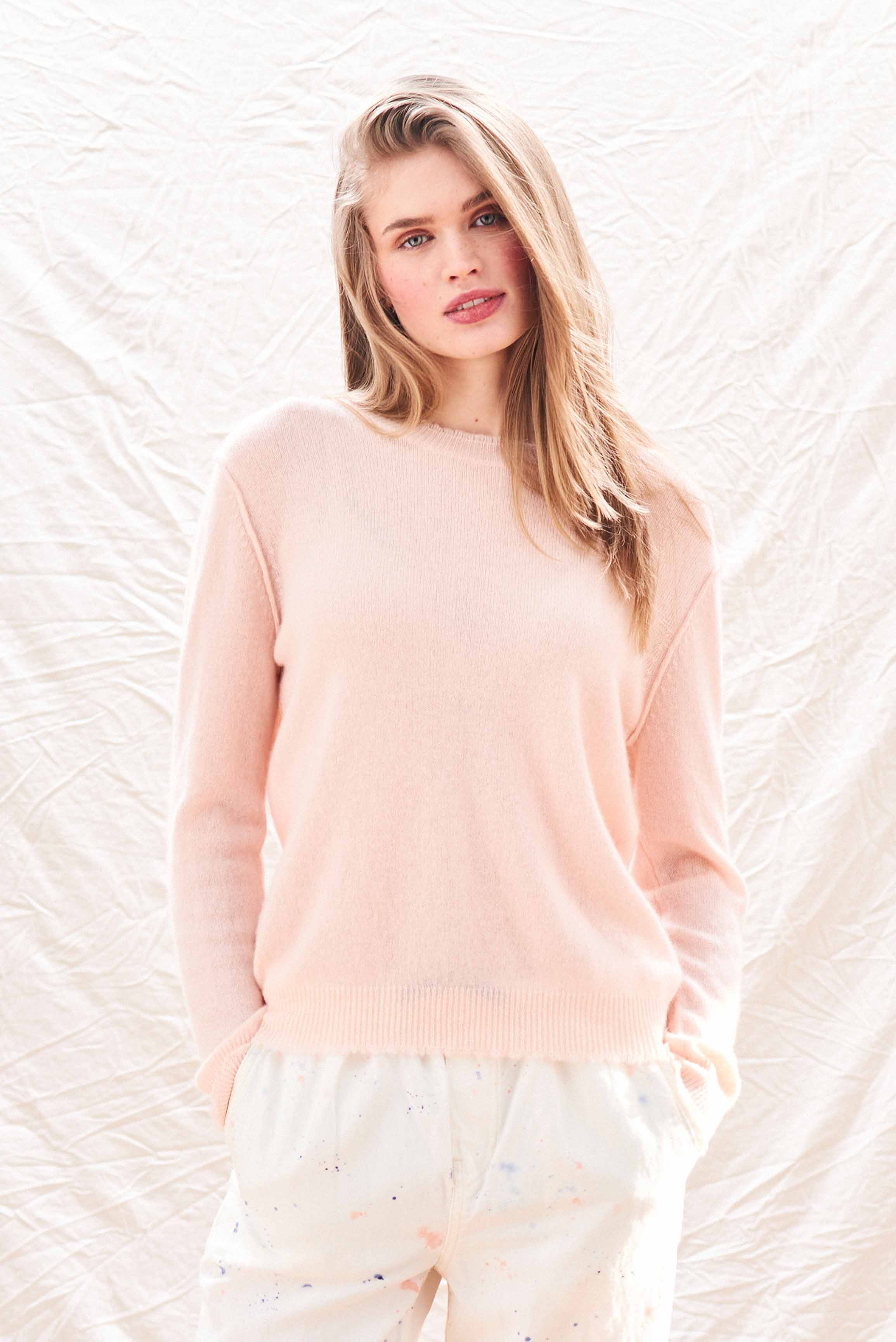 Female model wearing Jumper 1234 Pale pink cashmere crew neck with 'distressed' ribs.