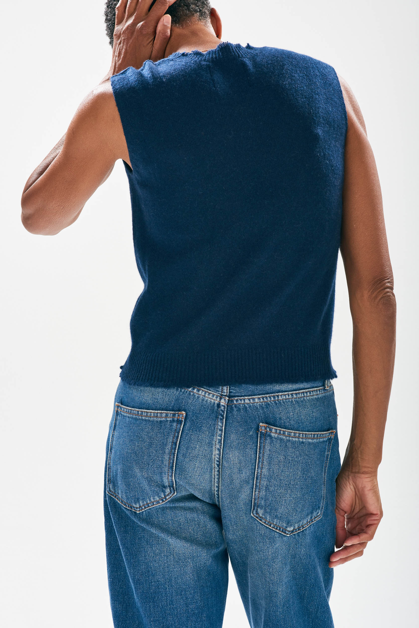 Model wearing Jumper1234 Navy cashmere crew neck tank with 'distressed' ribs facing away from the camera