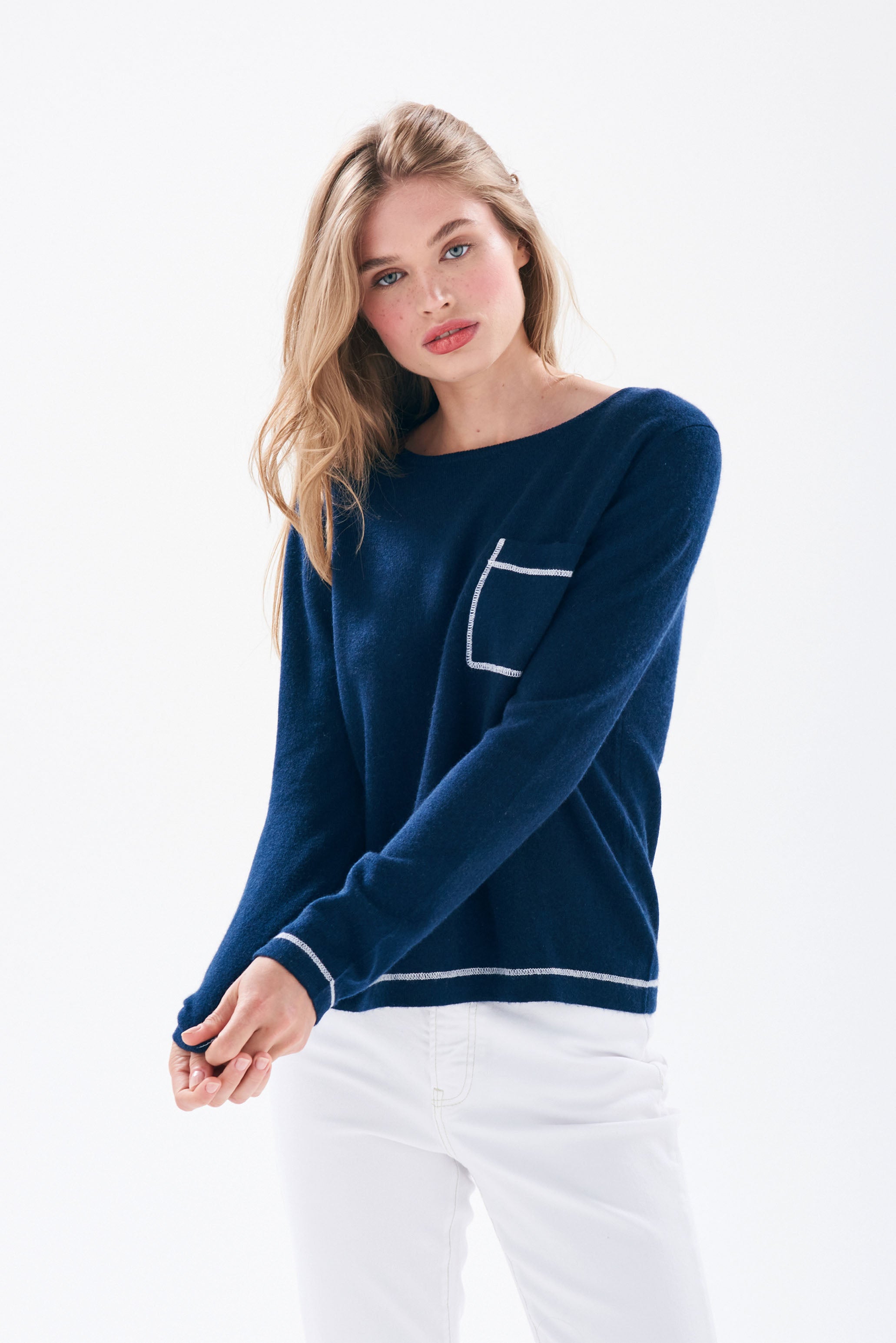 Model wearing Jumper1234 Navy cashmere crew neck jumper with cream top stitching detail and a chest pocket