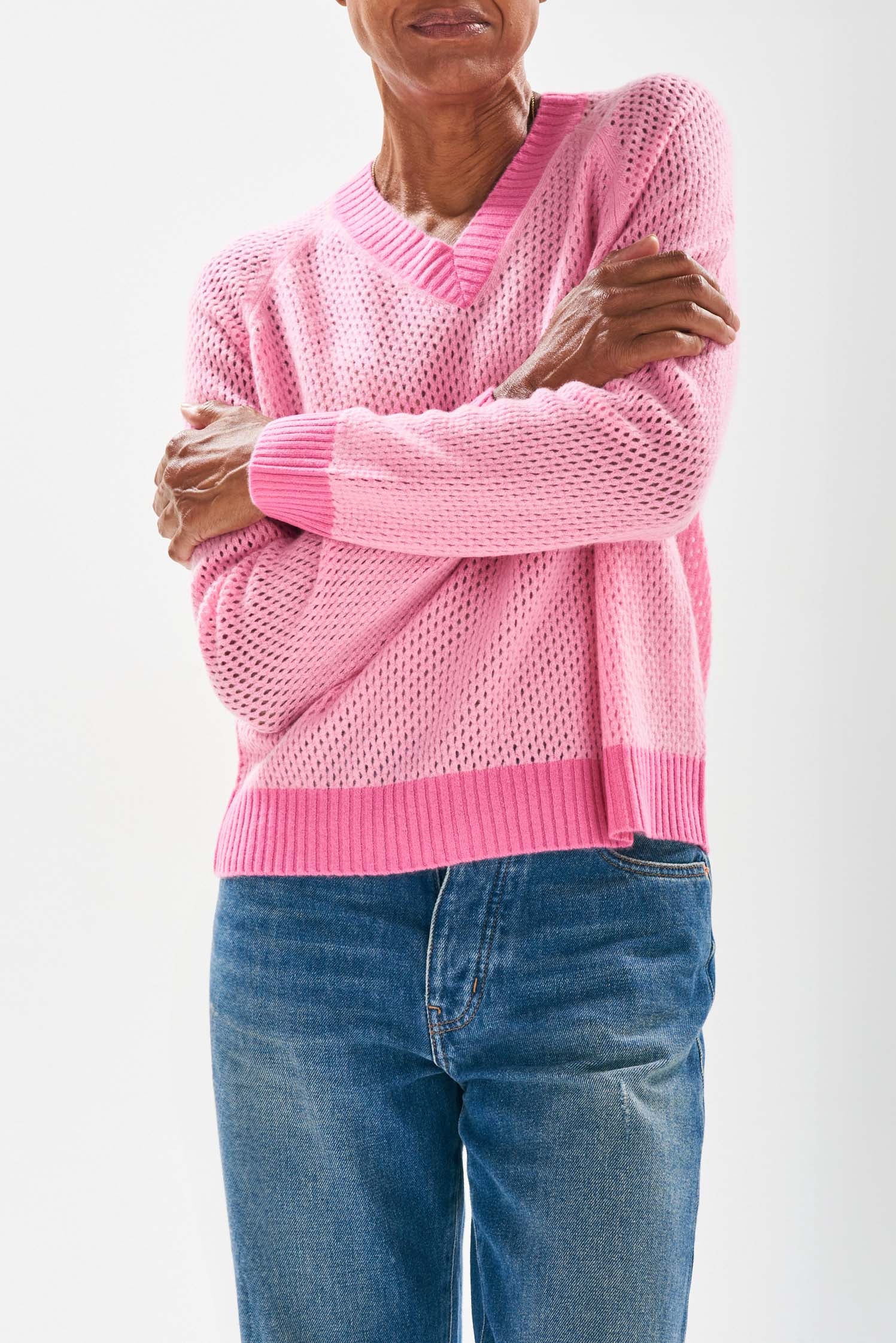 Model wearing Jumper1234 Mesh cashmere vee neck jumper in pink with contrast darker pink ribs