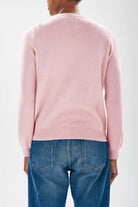 Model facing away from camera wearing Jumper1234 Pale pink cashmere crew neck jumper with red embroidered lifeguard detail