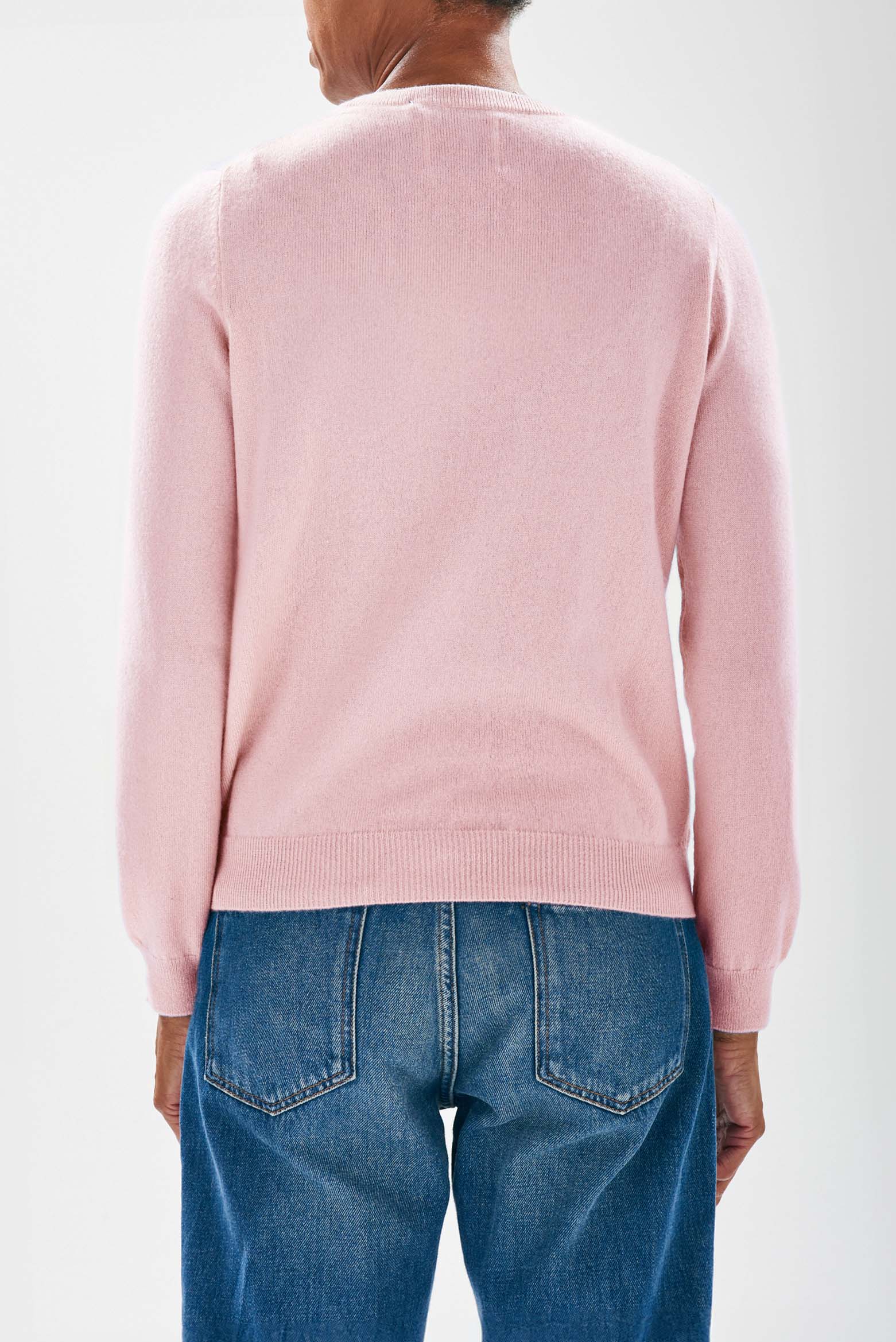 Model facing away from camera wearing Jumper1234 Pale pink cashmere crew neck jumper with red embroidered lifeguard detail